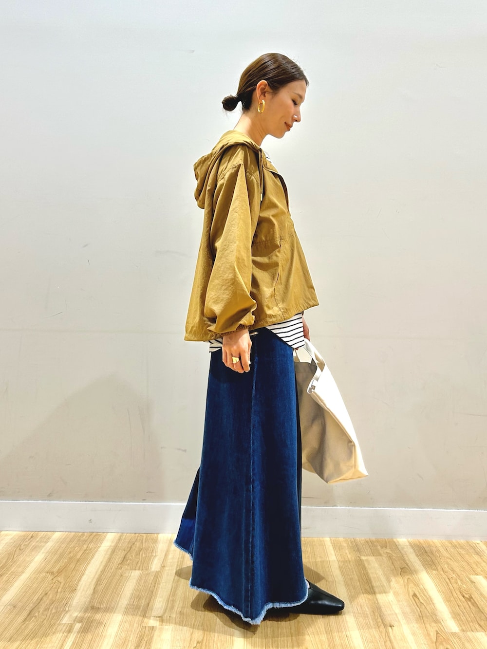 イエロー系のブルゾン、ホワイト系のTシャツ/カットソー、ブルー系のスカートを着用したレディースの春コーディネートの2枚目の写真