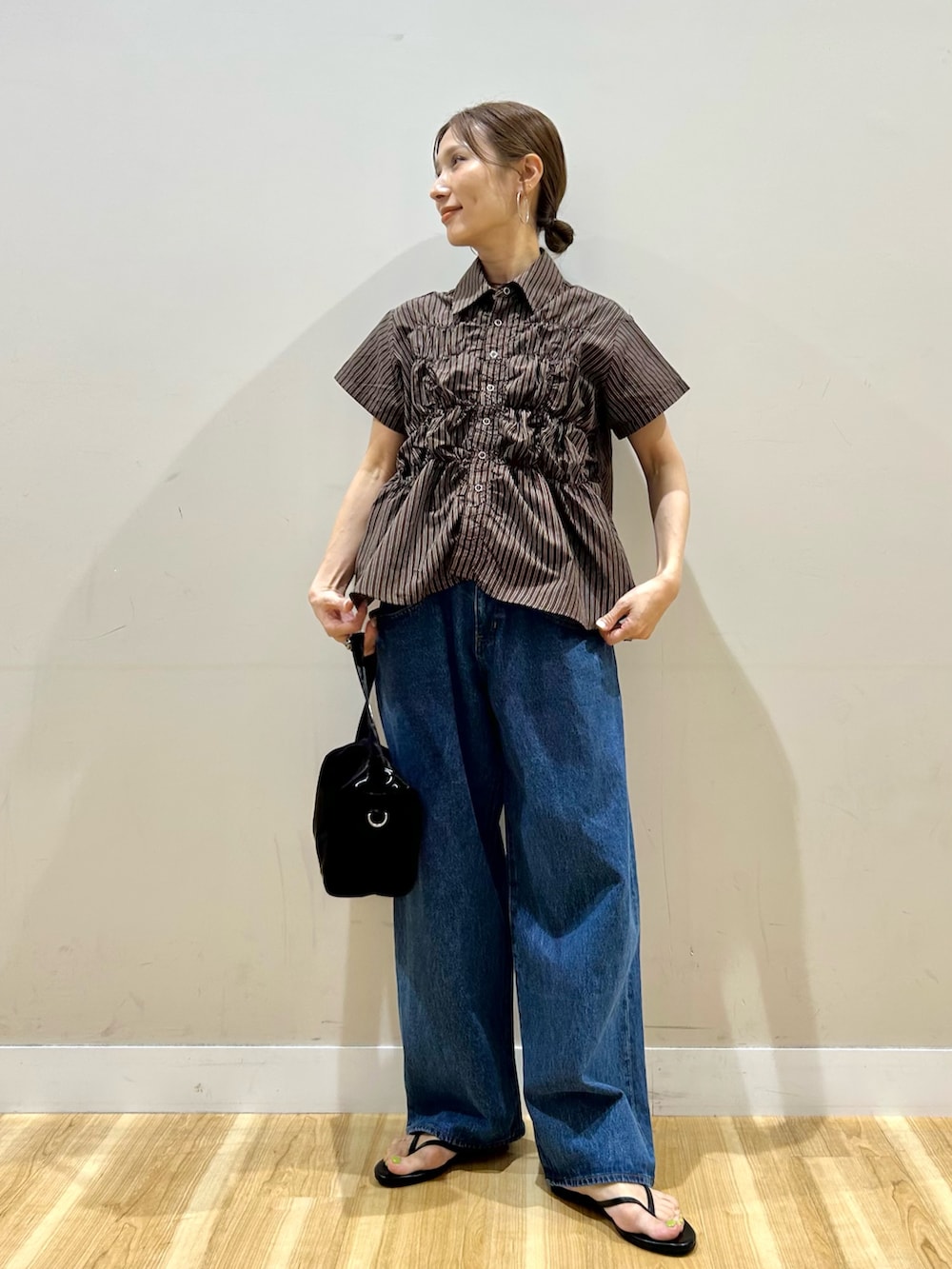 ブラウン系のシャツ/ブラウス、ブルー系のデニムパンツ、ブラック系のトートバッグを着用したレディースの夏コーディネートの5枚目の写真