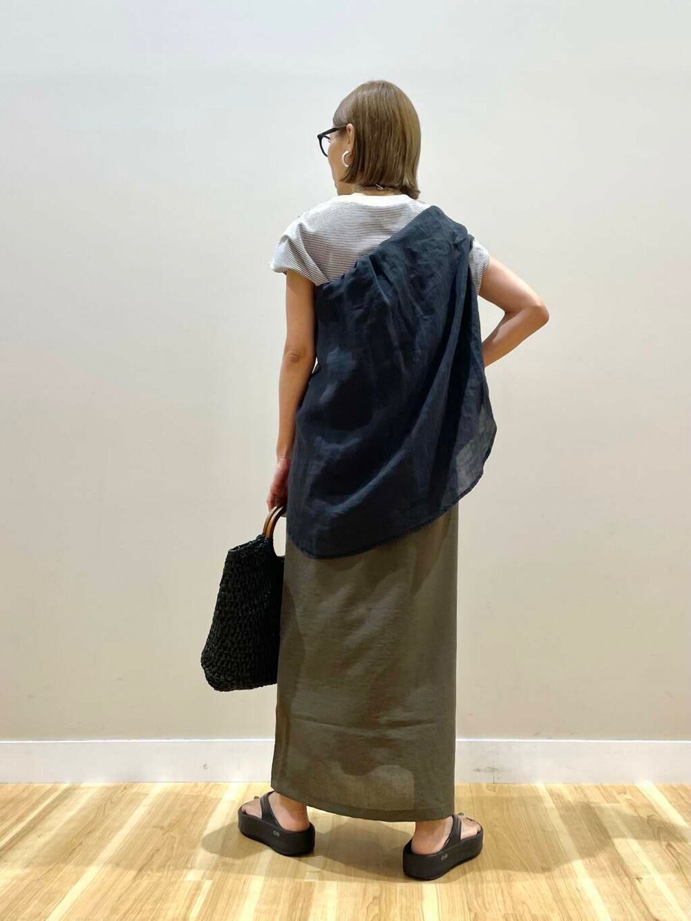 ブラック系のトートバッグ、ブラウン系のTシャツ/カットソー、ブラウン系のスカートを着用したレディースの夏コーディネートの3枚目の写真