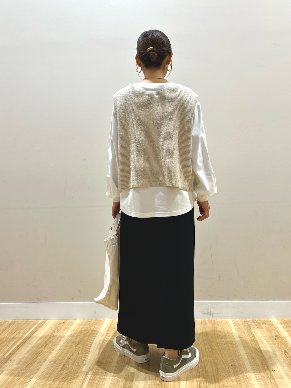 ベージュ系のマウンテンパーカー、ベージュ系のニット/セーター、ブラック系のスカートを着用したレディースの春コーディネートの5枚目の写真