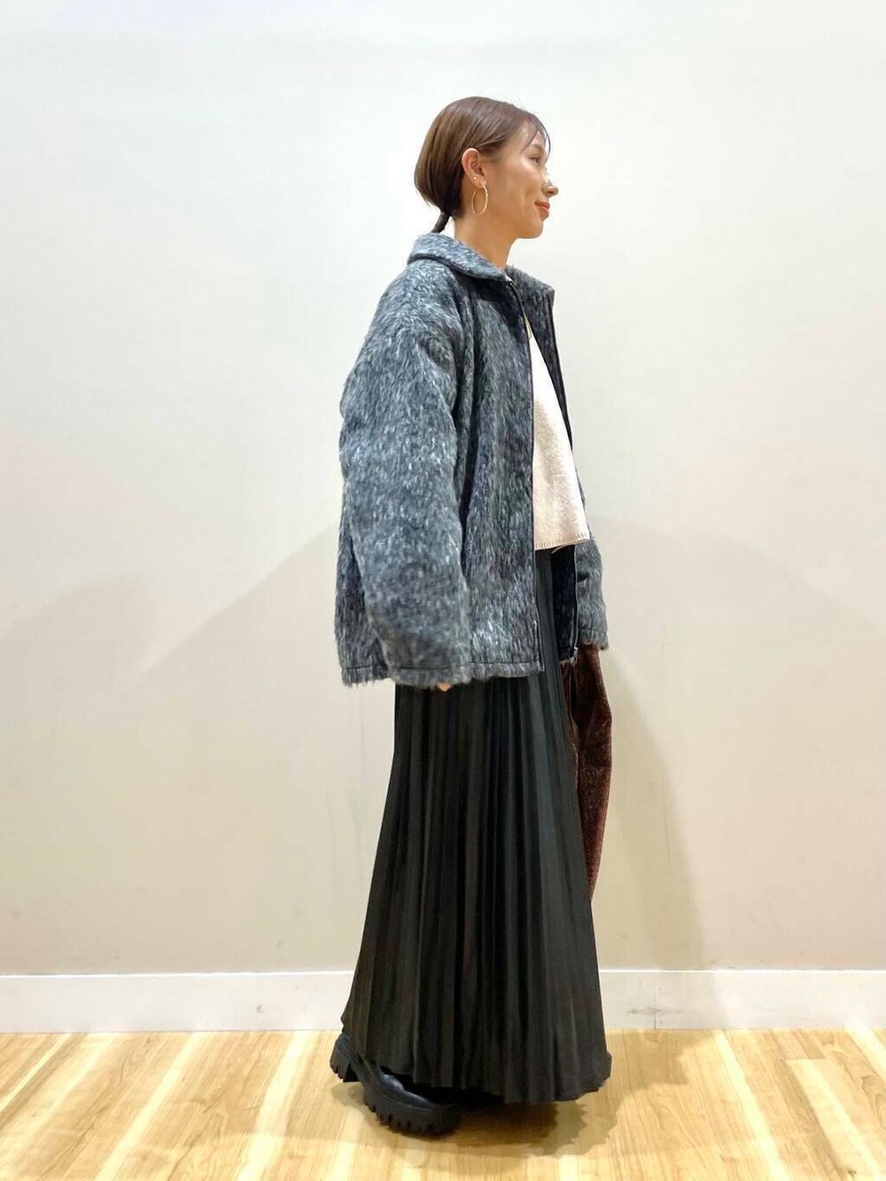 ブラック系のブーツ、ホワイト系のニット/セーター、ブラウン系のトートバッグを着用したレディースの冬コーディネートの4枚目の写真