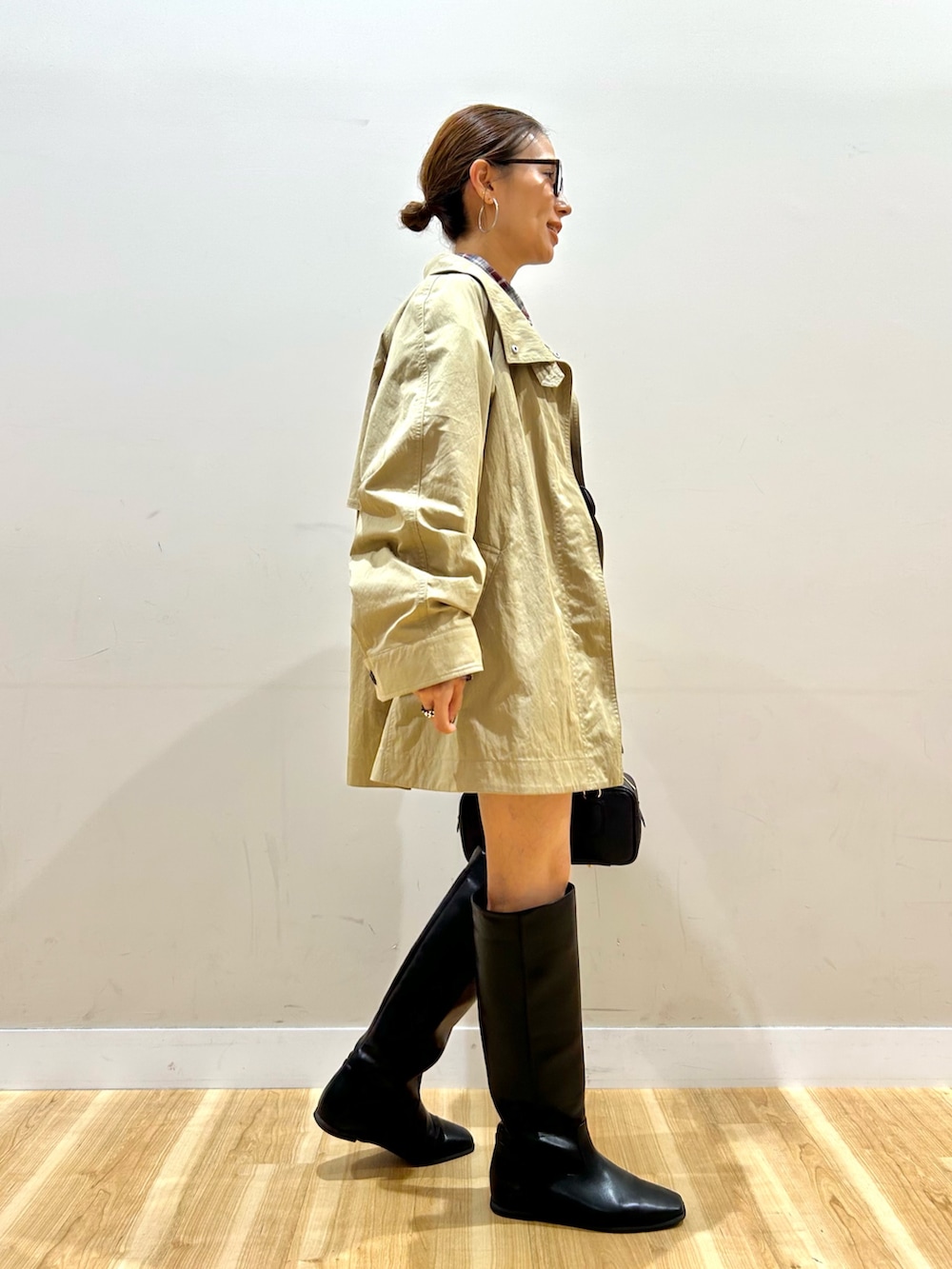 ベージュ系のその他アウター、レッド系のシャツ/ブラウス、ブラック系のハンドバッグを着用したレディースの秋コーディネートの2枚目の写真