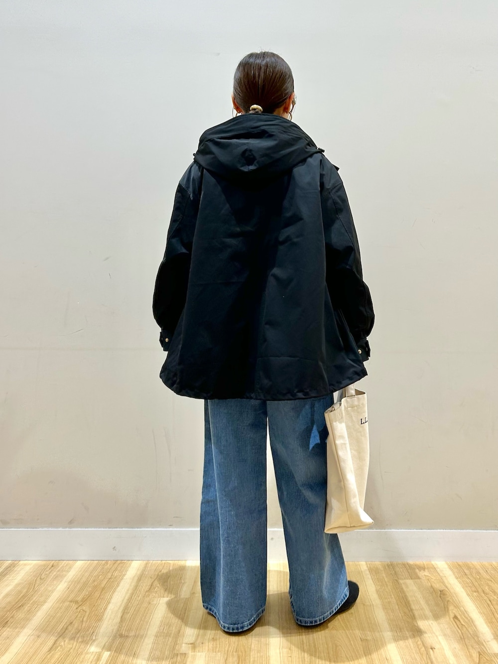 ブルー系のデニムパンツ、ベージュ系のショルダーバッグ、ピンク系のニット/セーターを着用したレディースの冬コーディネートの4枚目の写真