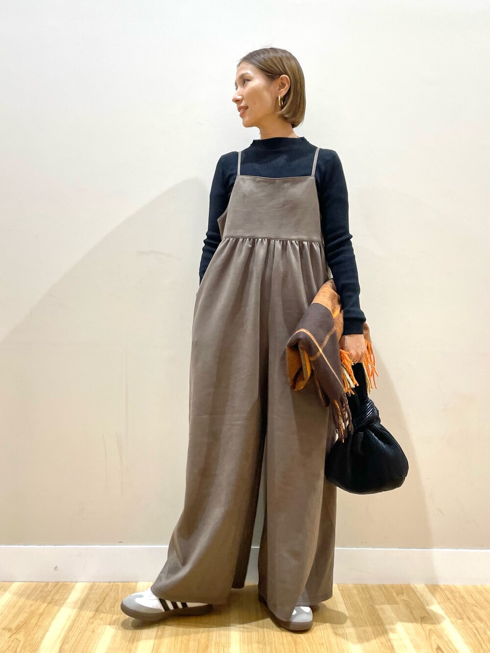 ブラック系のサロペット/オーバーオールを着用したレディースの秋コーディネートの2枚目の写真