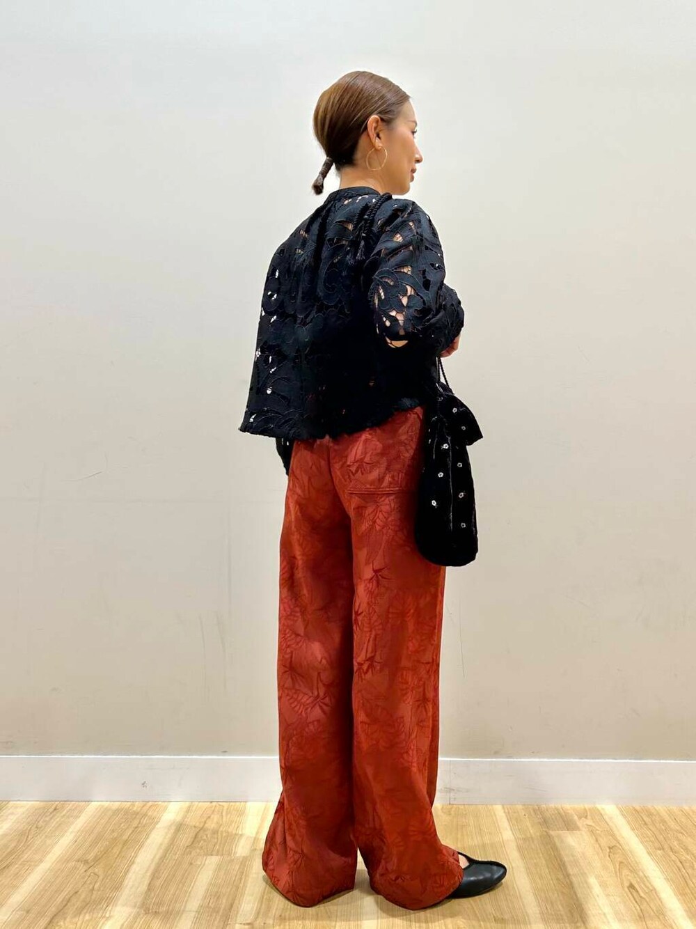 ブラック系のショルダーバッグ、オレンジ系のその他パンツ、ブラック系のシャツ/ブラウスを着用したレディースの春コーディネートの3枚目の写真