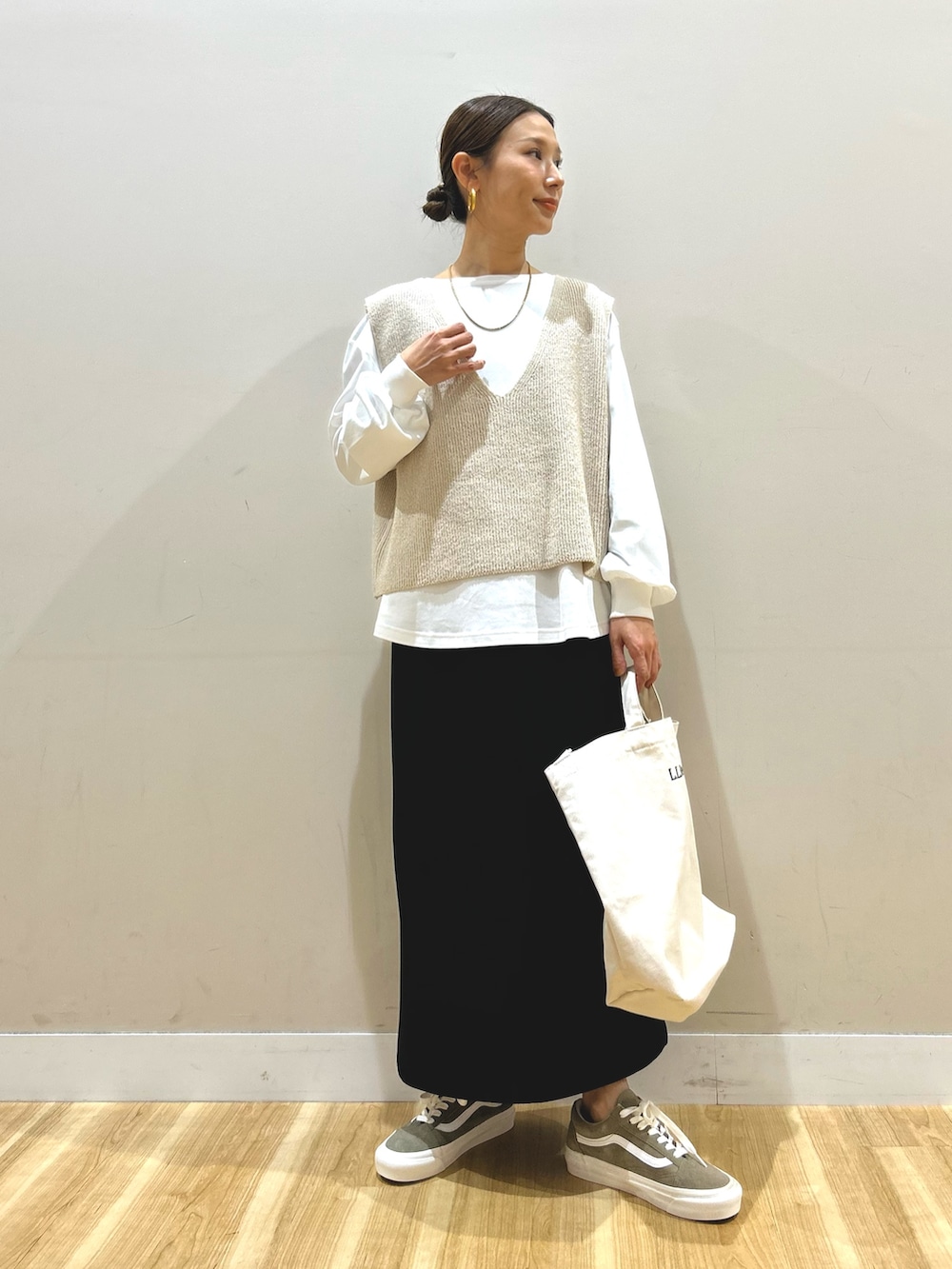 ベージュ系のマウンテンパーカー、ベージュ系のニット/セーター、ブラック系のスカートを着用したレディースの春コーディネートの4枚目の写真