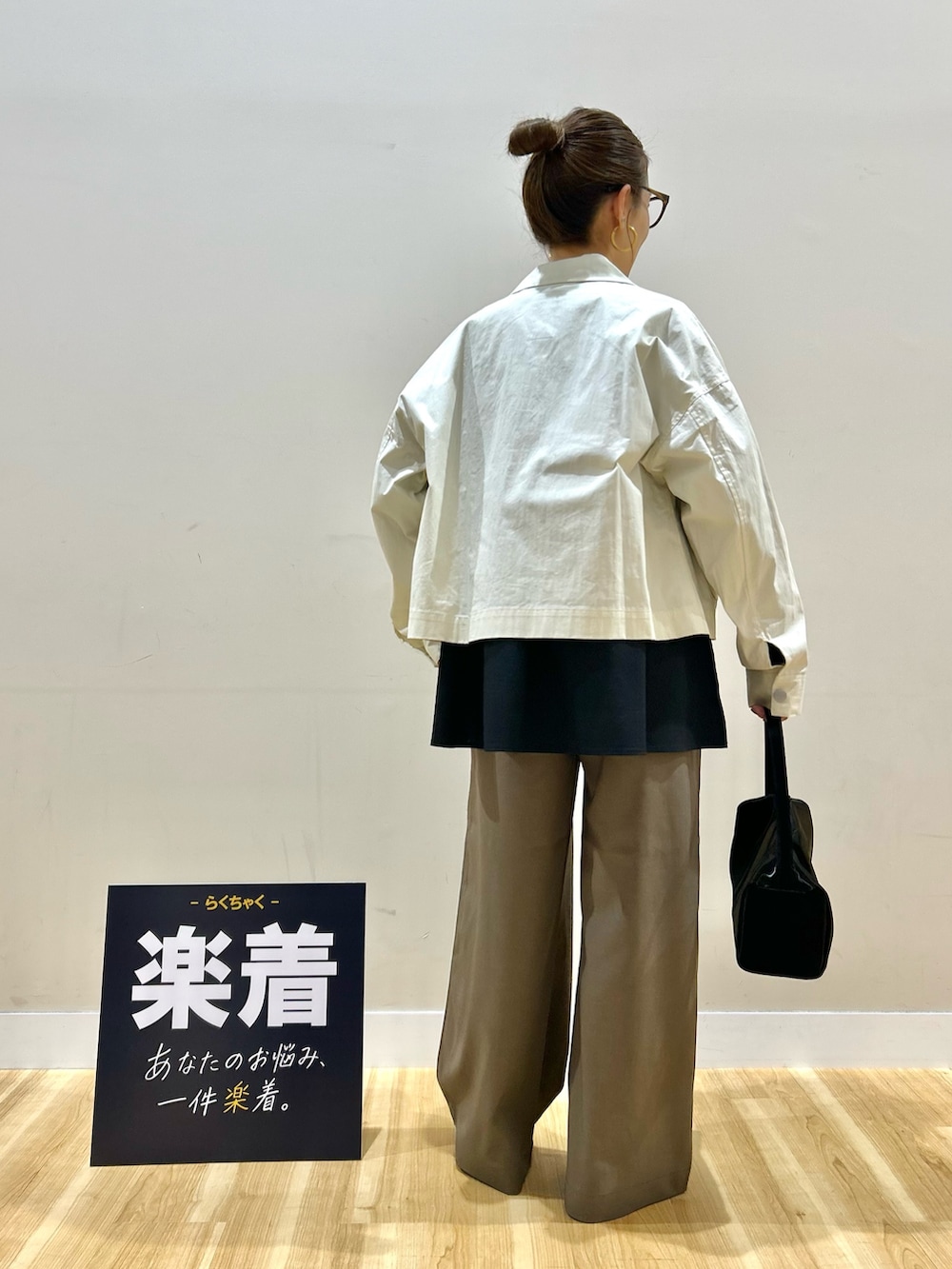 ホワイト系のブルゾン、ブラック系のシャツ/ブラウス、ブラック系のトートバッグを着用したレディースの春コーディネートの3枚目の写真