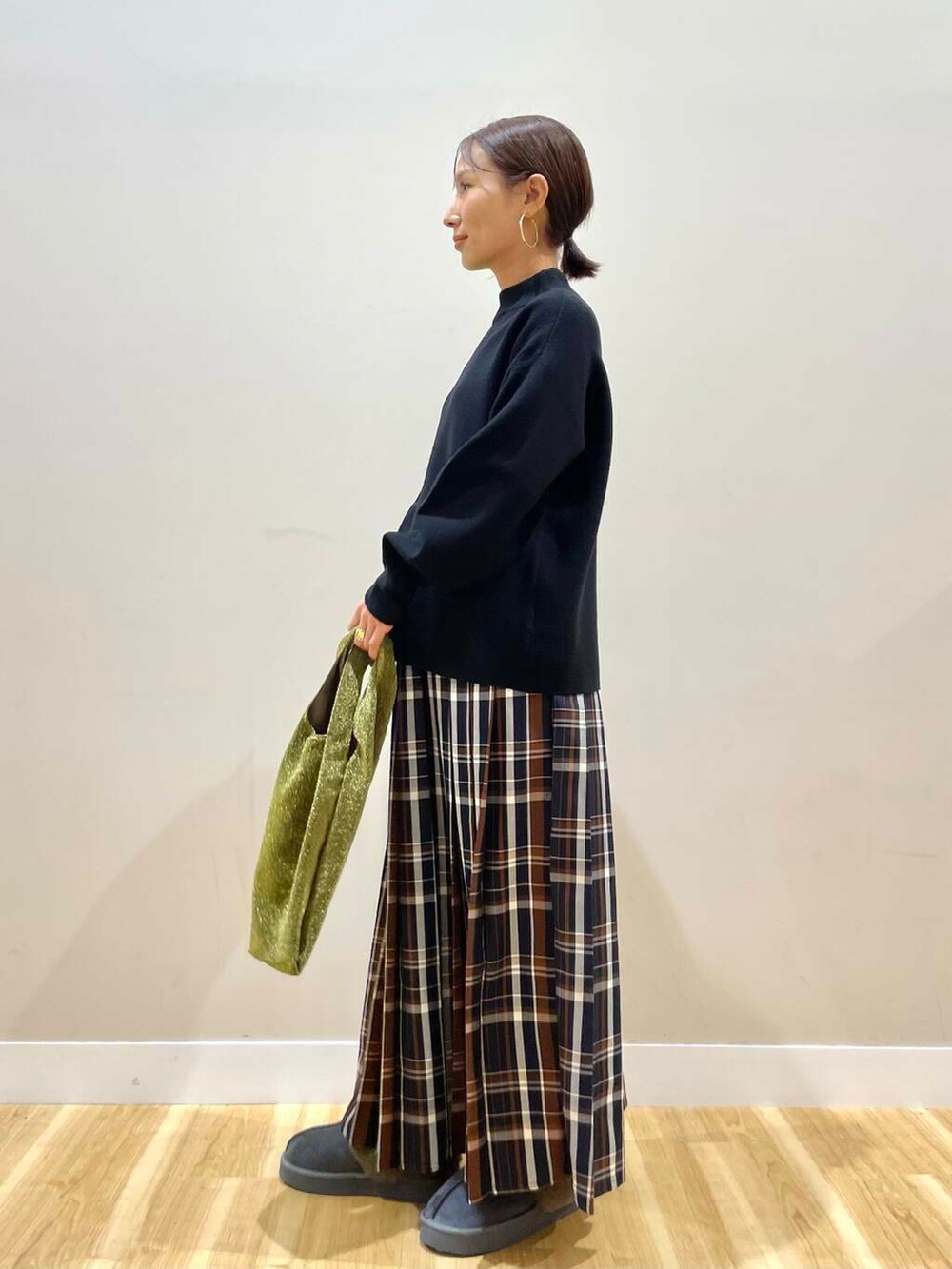 ゴールド系のトートバッグ、ブラック系のニット/セーター、ブルー系のスカートを着用したレディースの冬コーディネートの5枚目の写真