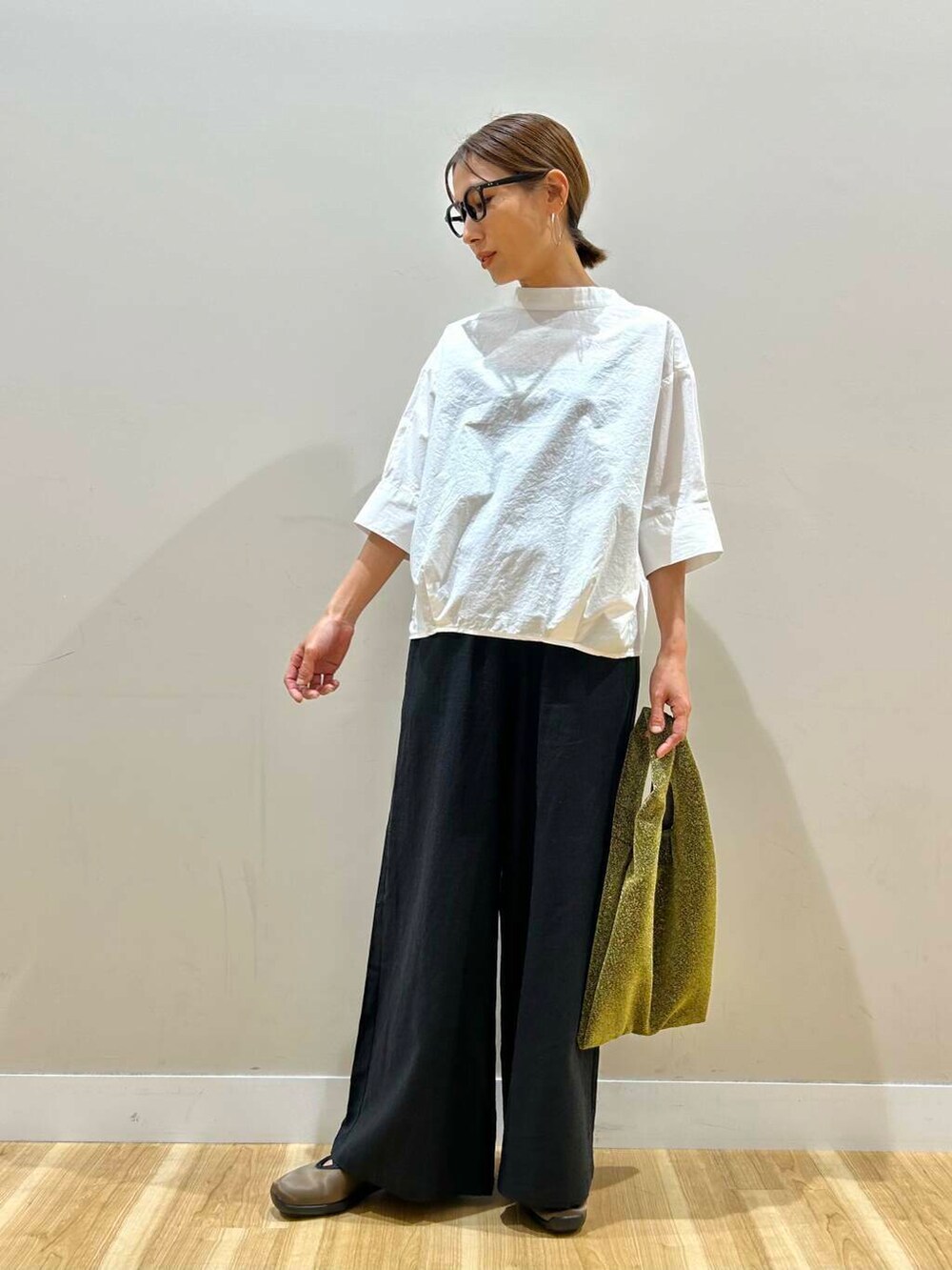 ゴールド系のトートバッグ、ブラック系のその他パンツ、ホワイト系のシャツ/ブラウスを着用したレディースの春コーディネートの5枚目の写真