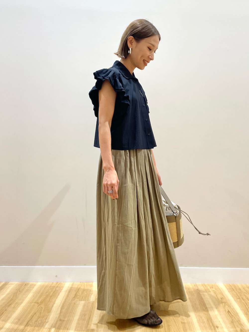 イエロー系のスカート、ブラック系のシャツ/ブラウスを着用したレディースの夏コーディネートの4枚目の写真