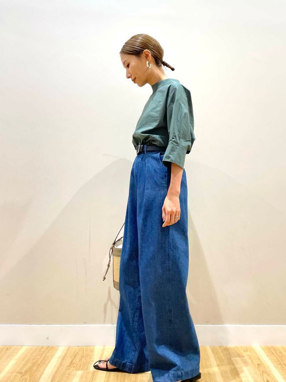 グリーン系のシャツ/ブラウス、ブルー系のデニムパンツ、ブラック系のベルトを着用したレディースの夏コーディネートの4枚目の写真