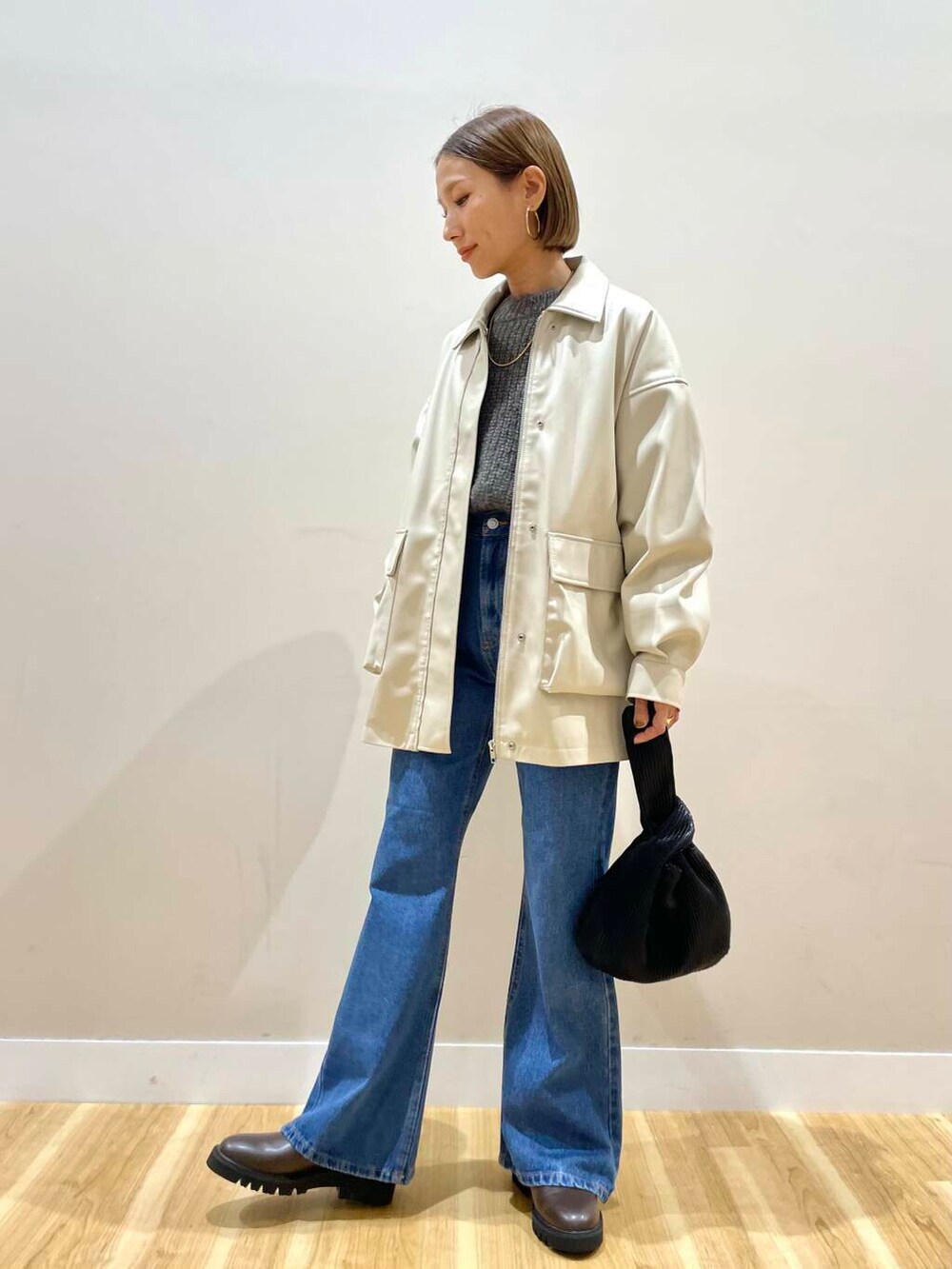 ブラウン系のブーツ、ブルー系のデニムパンツ、ブラック系のハンドバッグを着用したレディースの秋コーディネートの5枚目の写真