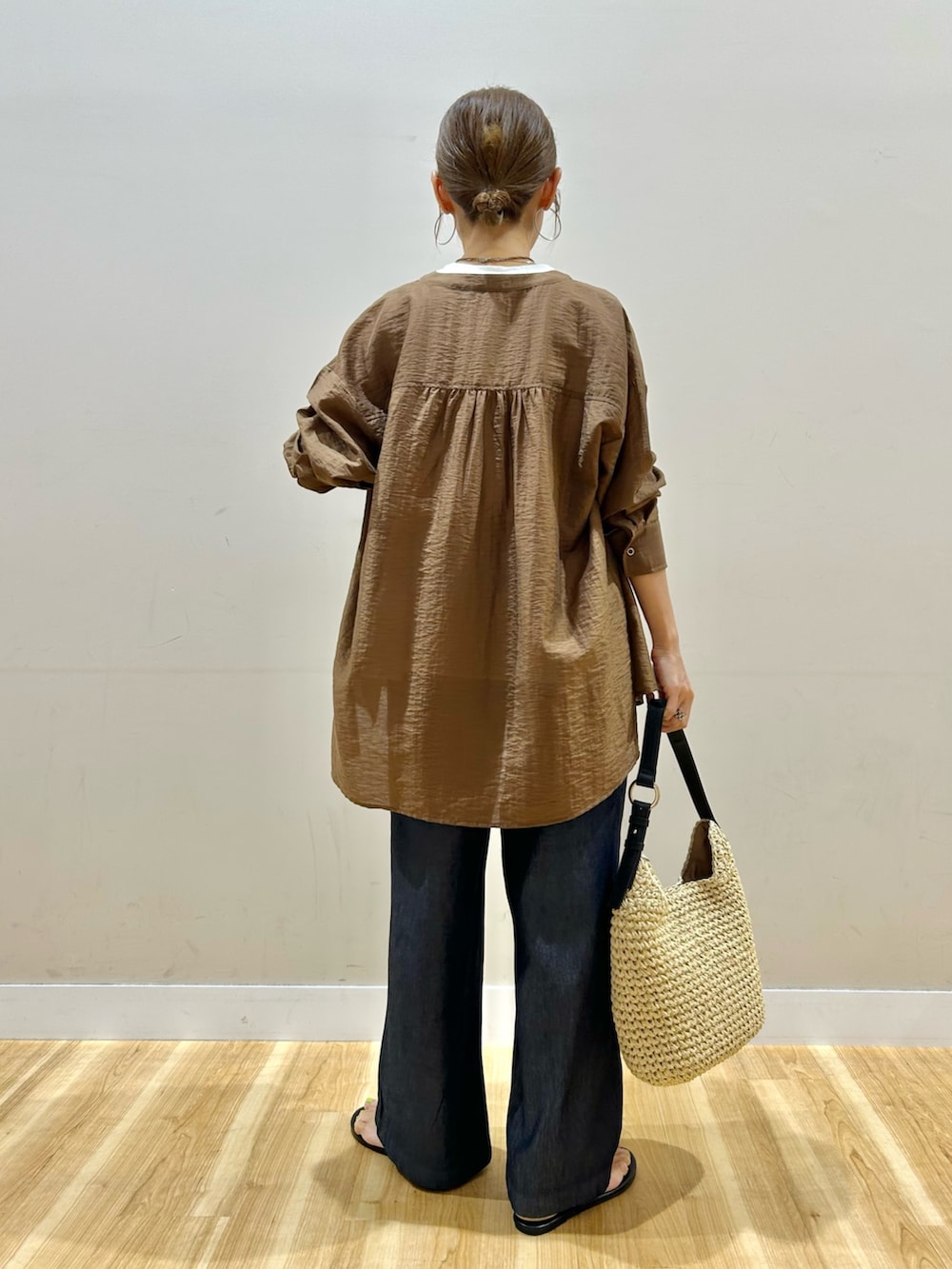 ブラウン系のシャツ/ブラウス、ホワイト系のTシャツ/カットソー、ブルー系のデニムパンツを着用したレディースの夏コーディネートの4枚目の写真