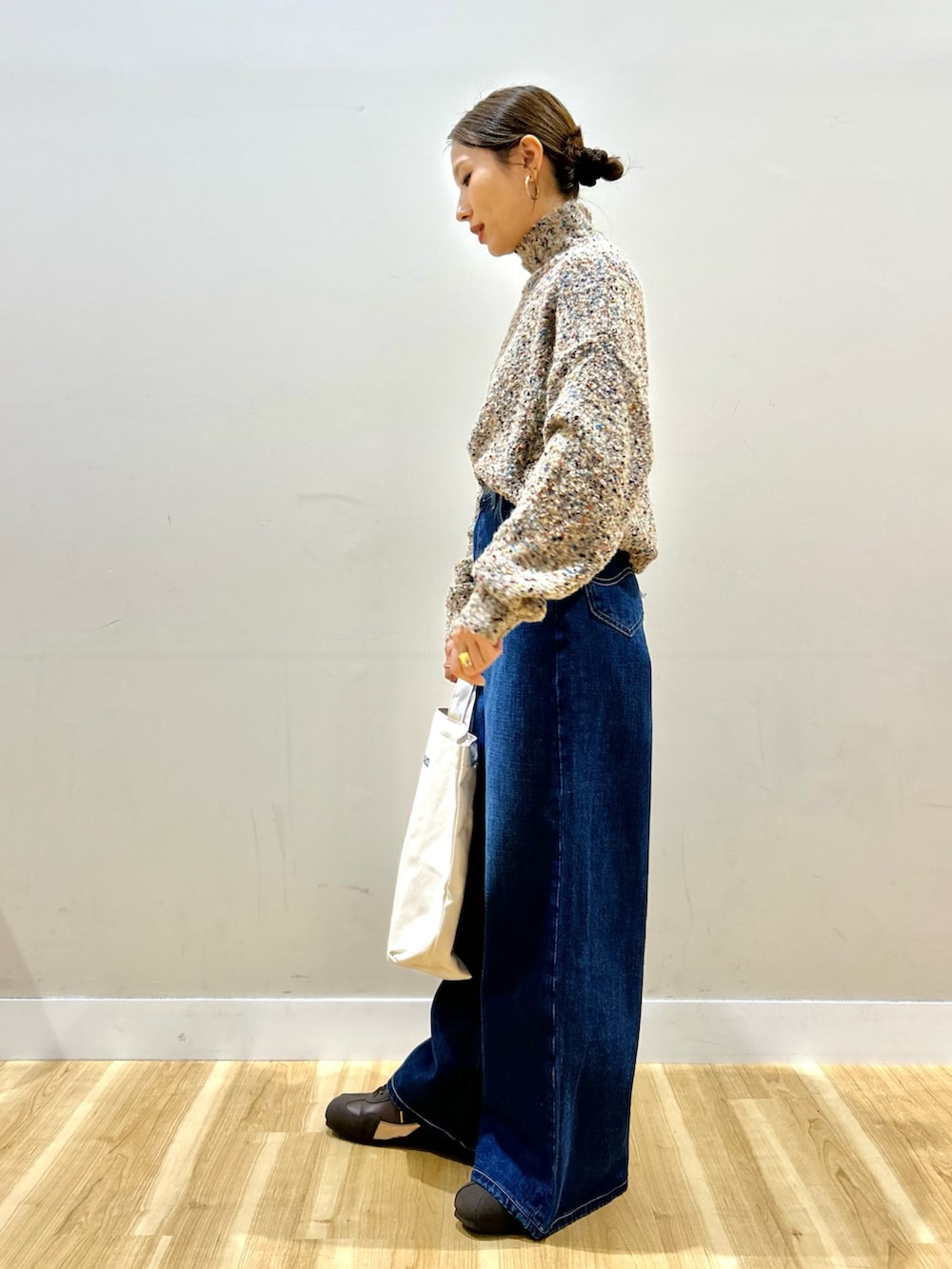 ブラック系のその他アウター、ベージュ系のニット/セーター、ブラウン系のスニーカーを着用したレディースの冬コーディネートの5枚目の写真