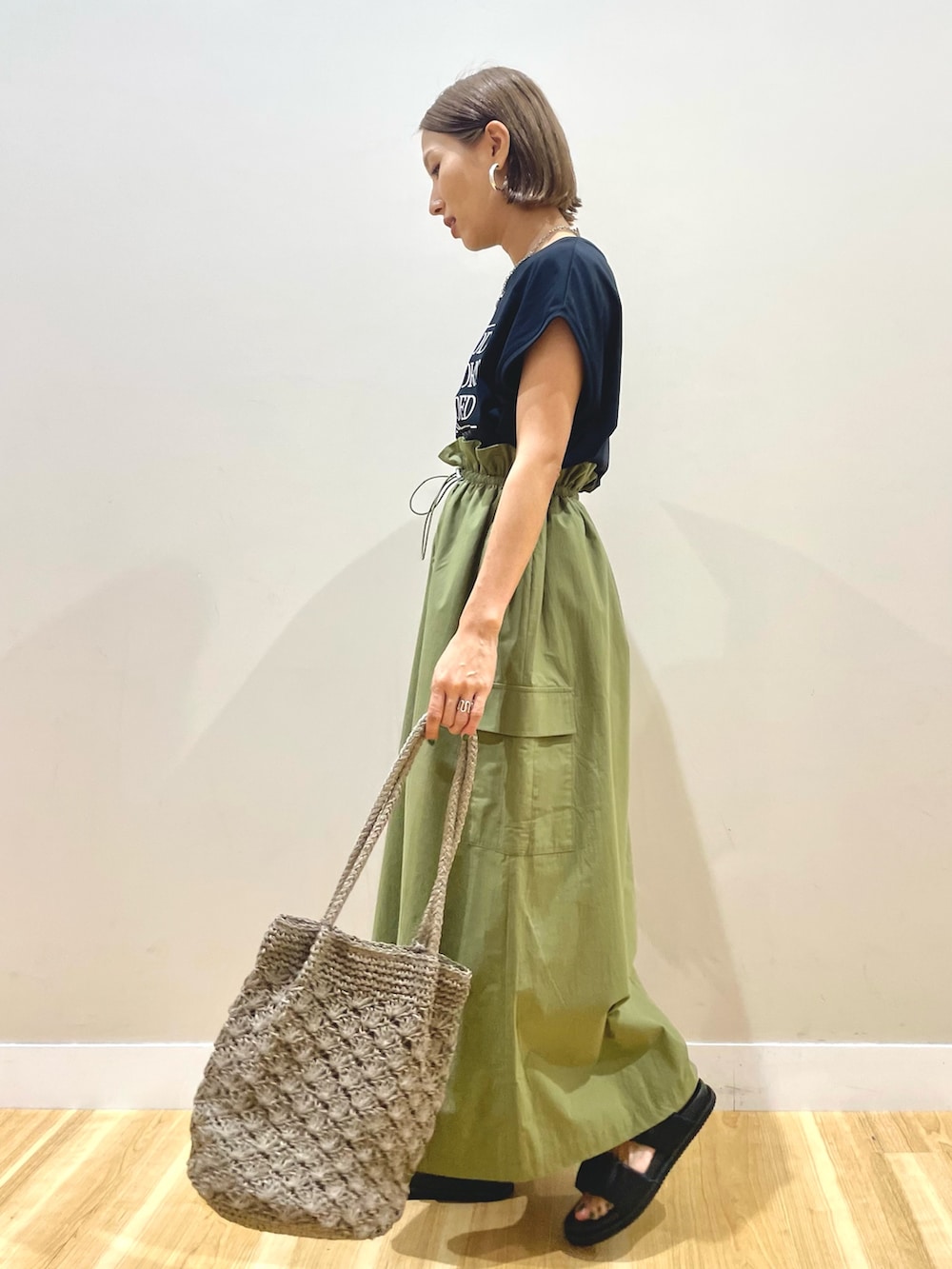 ブラック系のTシャツ/カットソー、グリーン系のスカートを着用したレディースの夏コーディネートの4枚目の写真