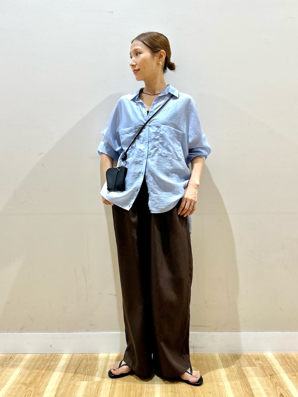ブルー系のシャツ/ブラウス、ブラウン系のその他パンツ、ブラック系のショルダーバッグを着用したレディースの秋コーディネートの4枚目の写真