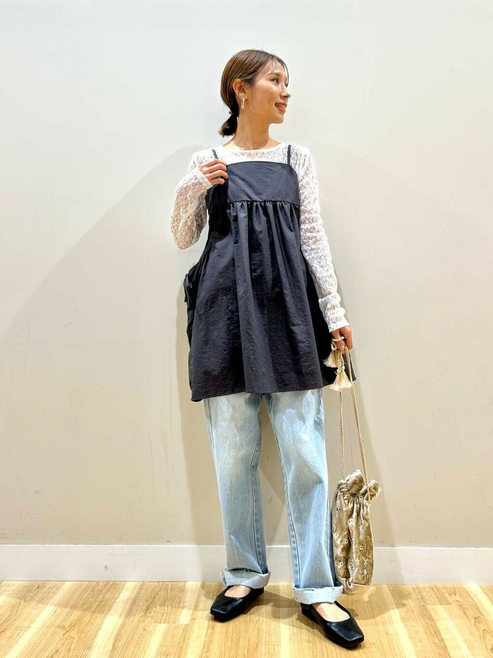 ブルー系のデニムパンツ、ベージュ系のショルダーバッグ、ブラック系のパンプスを着用したレディースの春コーディネートの4枚目の写真