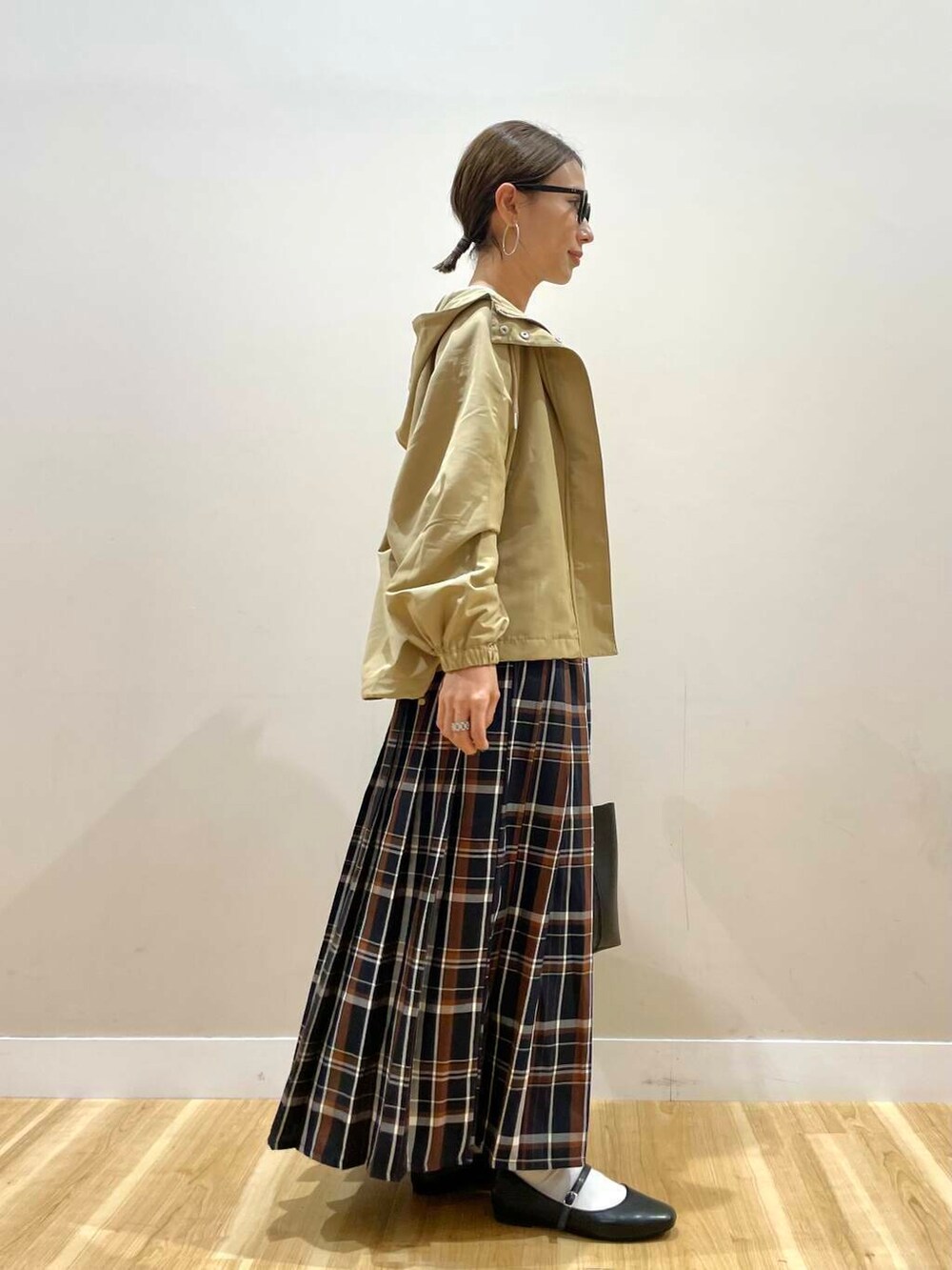 ブラック系のパンプス、ブラック系のトートバッグ、ブルー系のスカートを着用したレディースの秋コーディネートの4枚目の写真