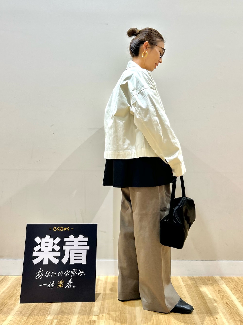 ホワイト系のブルゾン、ブラック系のシャツ/ブラウス、ブラック系のトートバッグを着用したレディースの春コーディネートの2枚目の写真