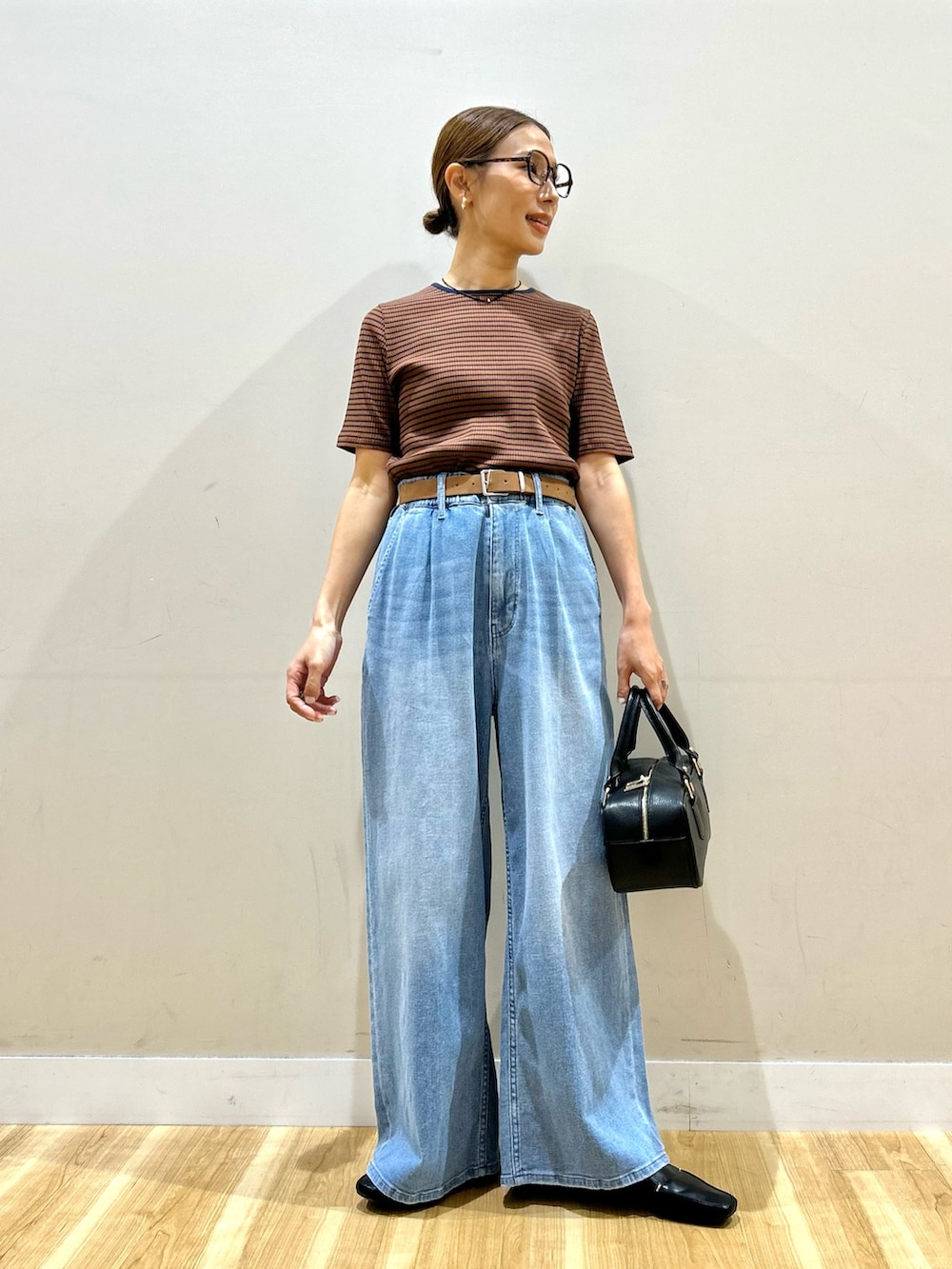 ブラウン系のTシャツ/カットソー、ブルー系のデニムパンツ、ブラック系のハンドバッグを着用したレディースの夏コーディネートの5枚目の写真