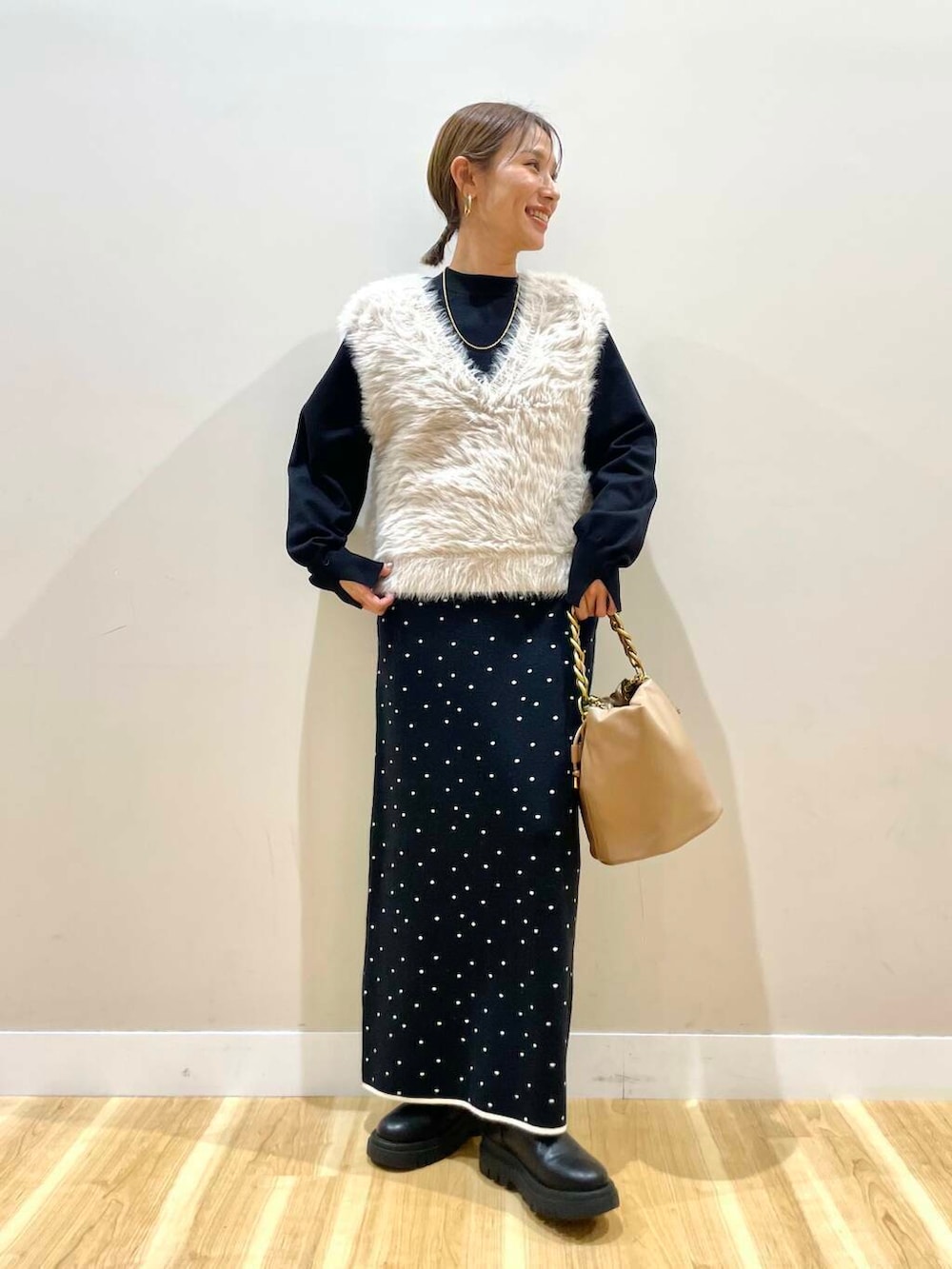 ブラウン系のショルダーバッグ、ブラック系のニット/セーター、ブラック系のスカートを着用したレディースの冬コーディネートの5枚目の写真