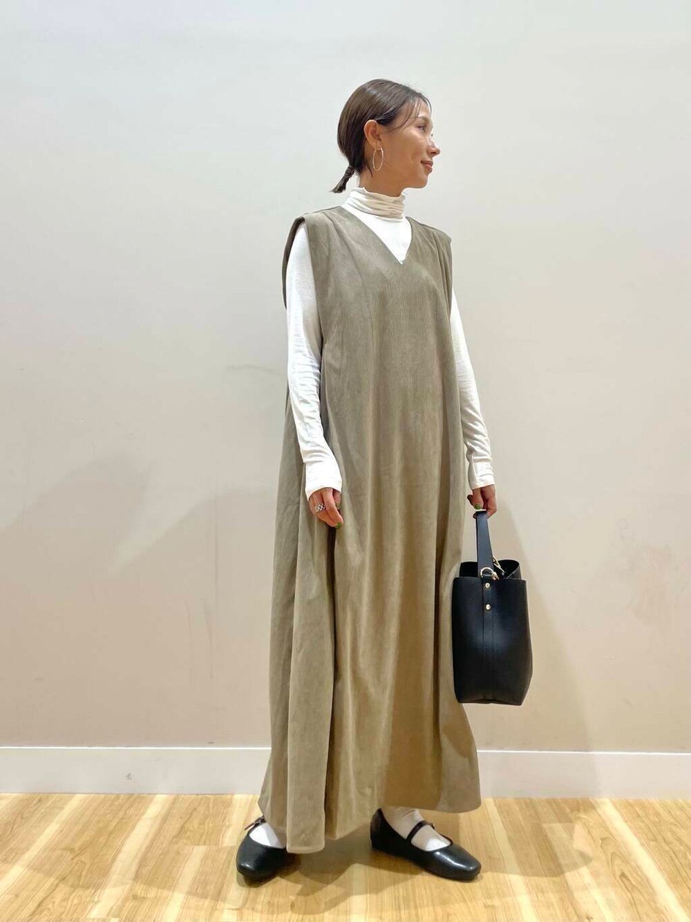 ブラック系のパンプス、ブラック系のトートバッグ、ホワイト系のTシャツ/カットソーを着用したレディースの秋コーディネートの4枚目の写真