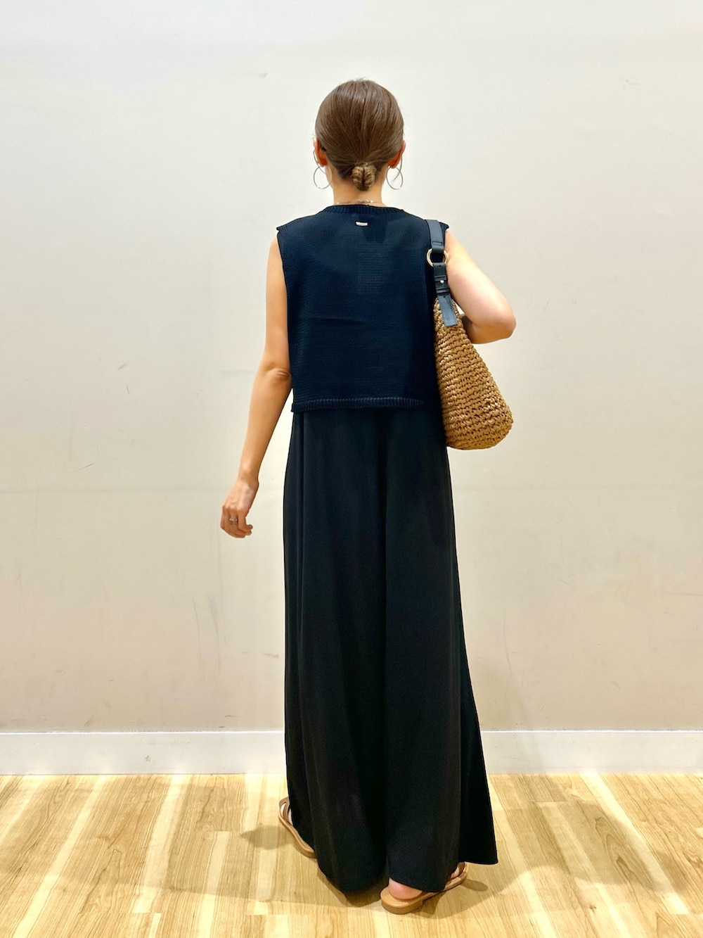 ブラック系のワンピース、ブラウン系のサンダル、ブラウン系のメガネを着用したレディースの夏コーディネートの3枚目の写真