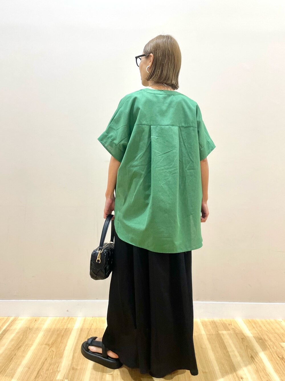 グリーン系のシャツ/ブラウス、ブラック系のワンピース、ブルー系のデニムパンツを着用したレディースの夏コーディネートの3枚目の写真