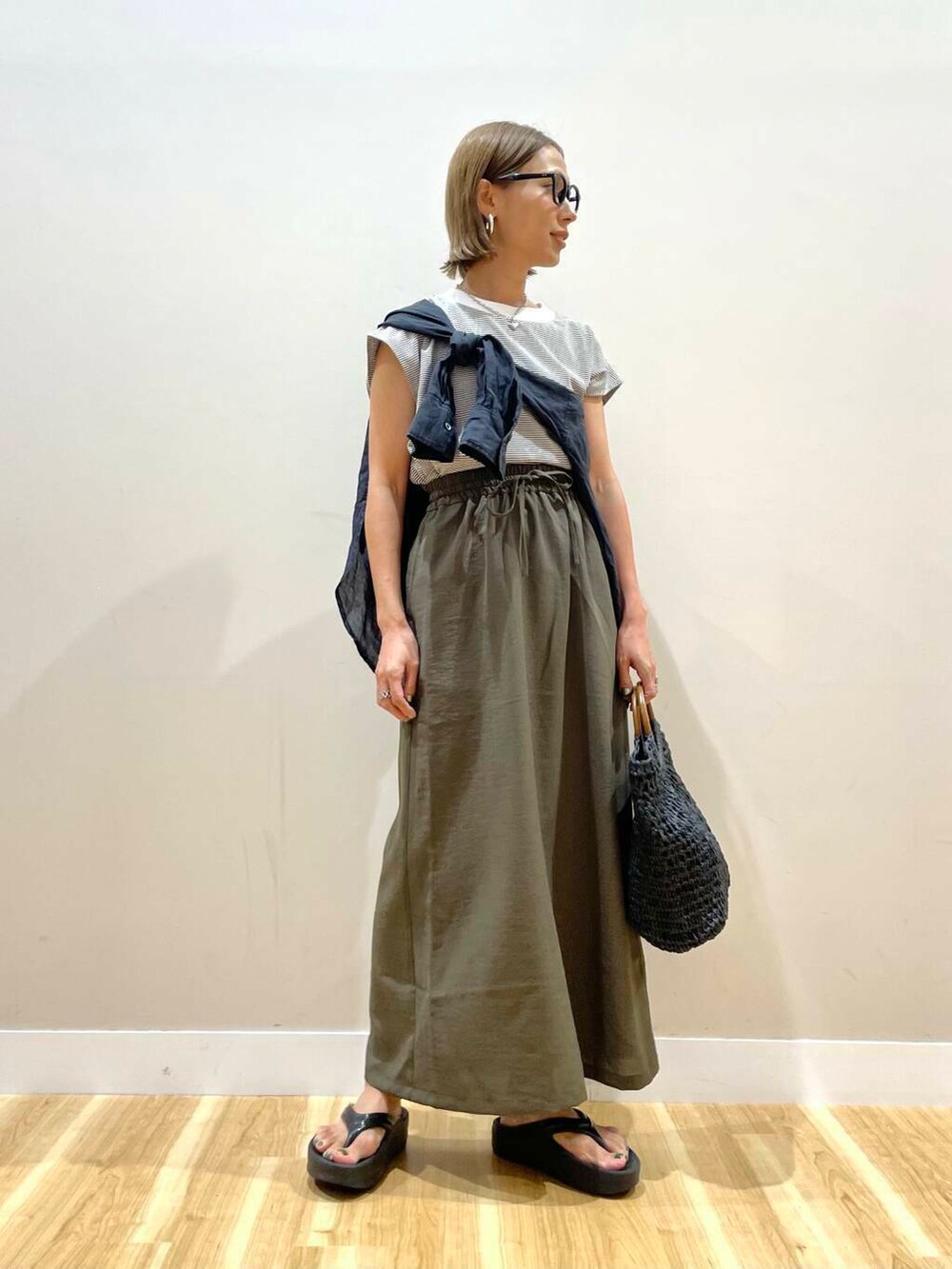 ブラック系のトートバッグ、ブラウン系のTシャツ/カットソー、ブラウン系のスカートを着用したレディースの夏コーディネートの5枚目の写真