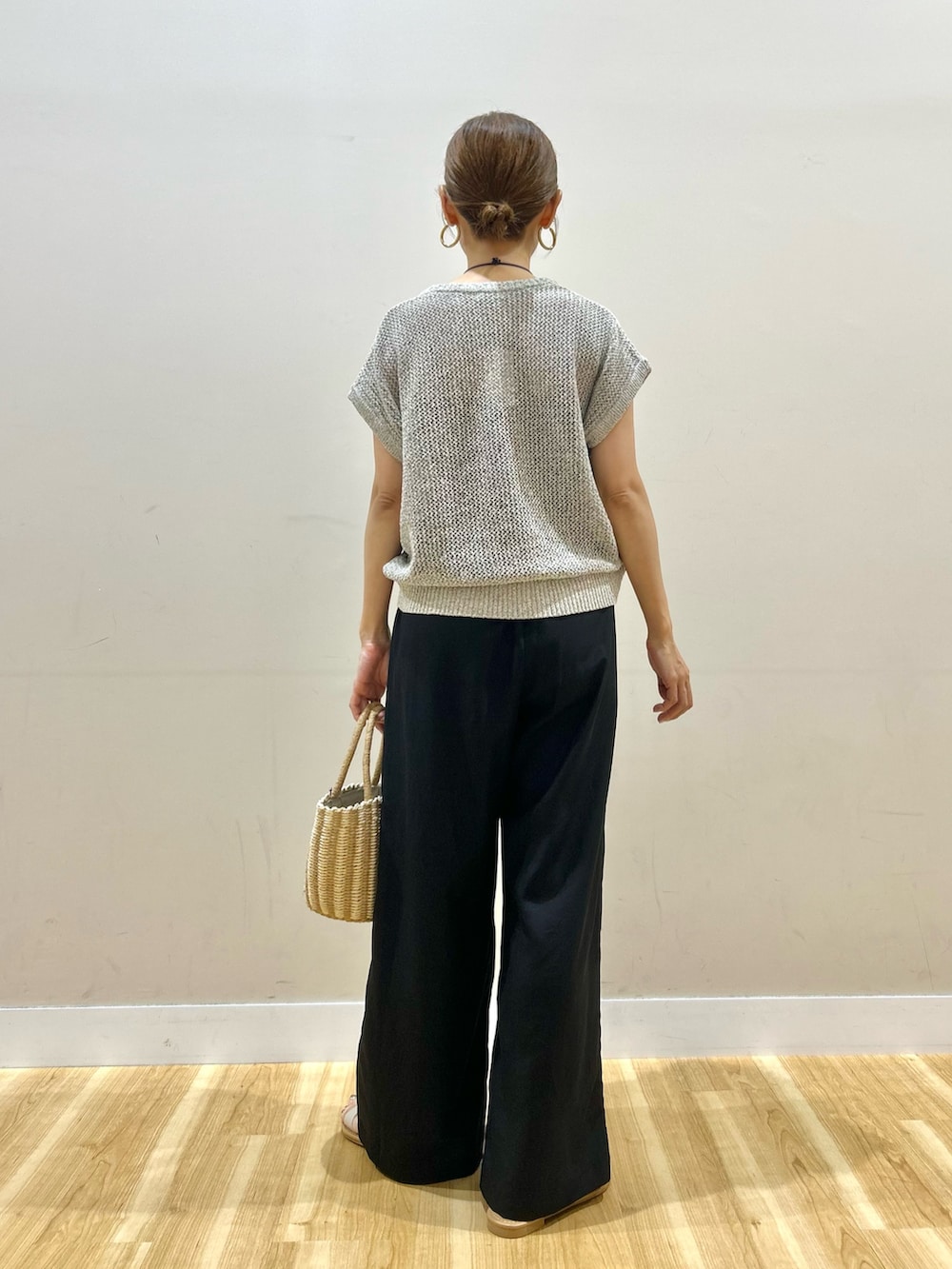 ホワイト系のベスト、ブラック系のその他パンツ、グレー系のハンドバッグを着用したレディースの夏コーディネートの3枚目の写真