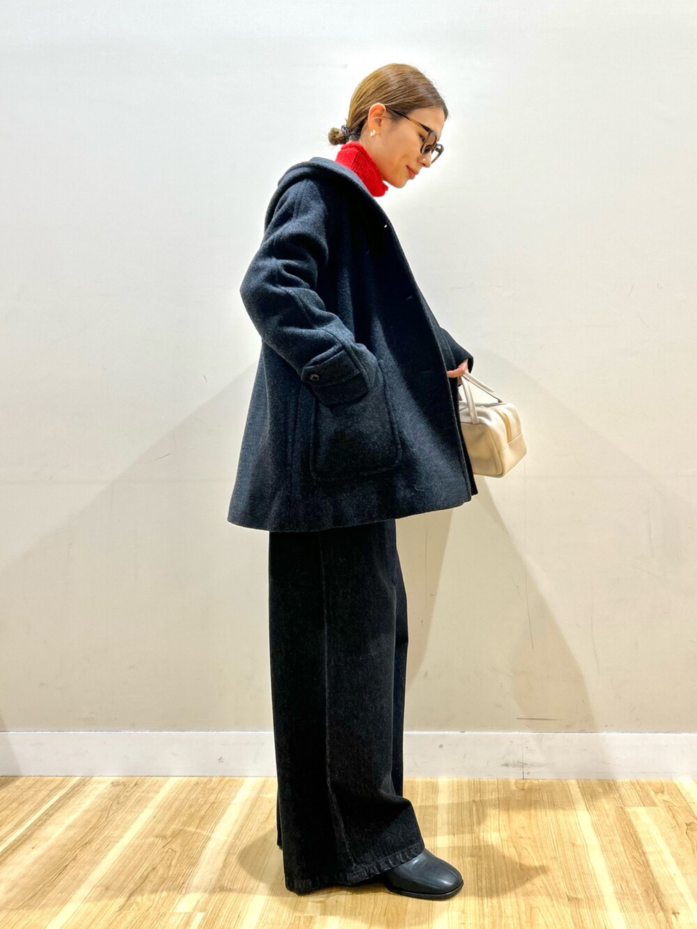 グレー系のその他アウター、レッド系のニット/セーター、ブラック系のデニムパンツを着用したレディースの冬コーディネートの2枚目の写真