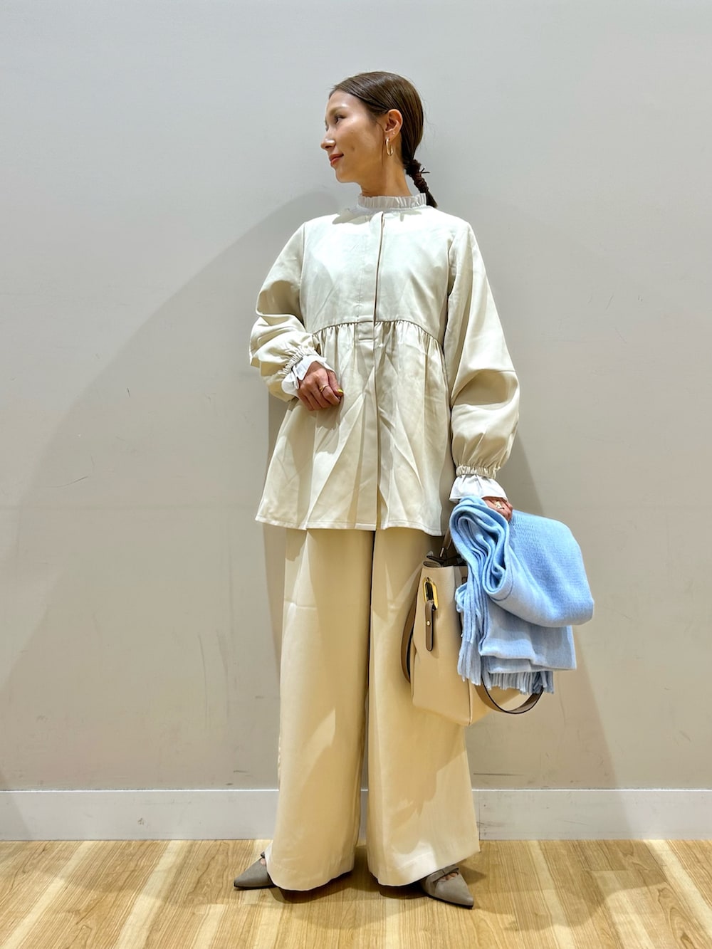ベージュ系のセットアップ、ホワイト系のトートバッグを着用したレディースの秋コーディネートの5枚目の写真