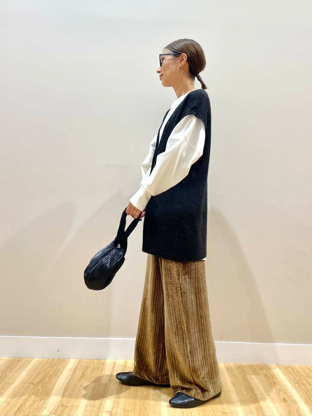 ブラック系のハンドバッグ、ホワイト系のTシャツ/カットソー、ブラウン系のその他パンツを着用したレディースの秋コーディネートの5枚目の写真