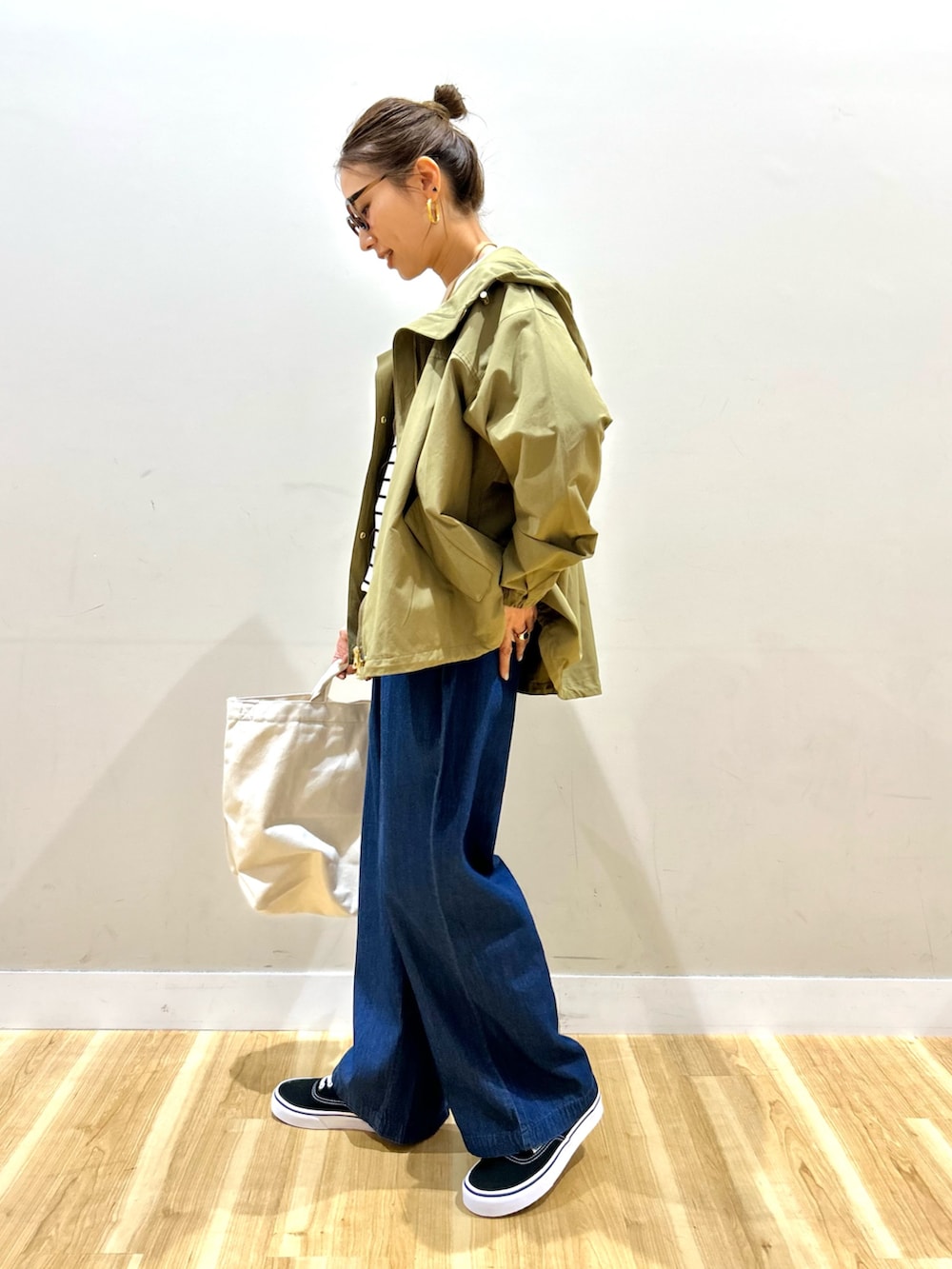 ベージュ系のマウンテンパーカー、ホワイト系のニット/セーター、ブルー系のその他パンツを着用したレディースの春コーディネートの2枚目の写真