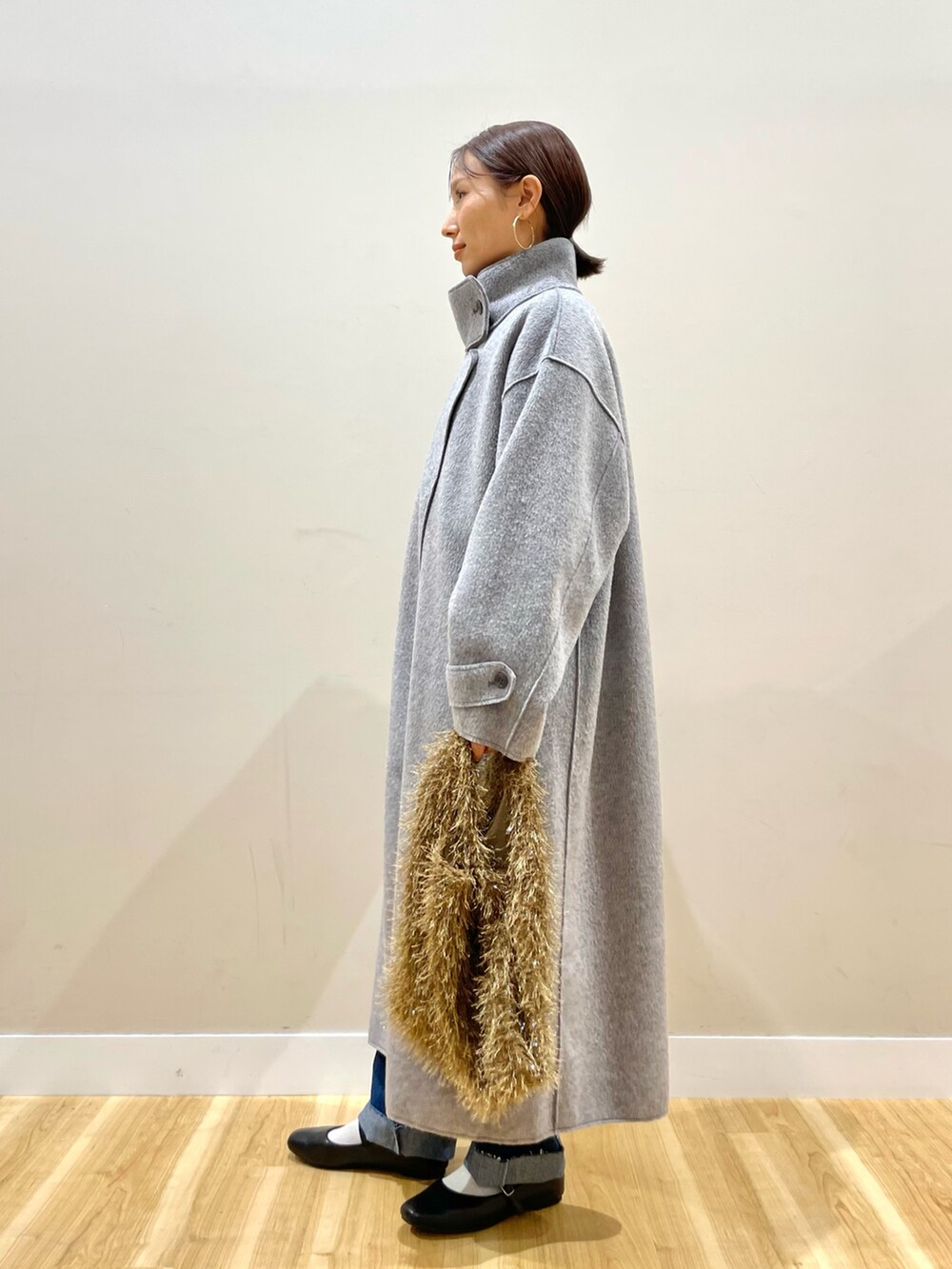 グレー系のその他アウター、ブラック系のニット/セーター、ブルー系のデニムパンツを着用したレディースの冬コーディネートの3枚目の写真