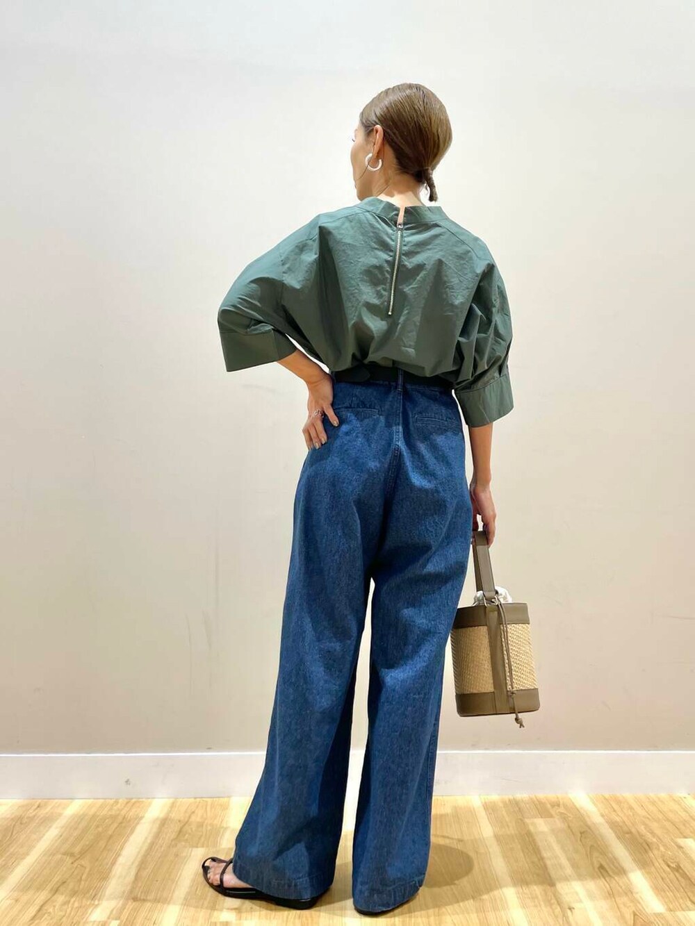 グリーン系のシャツ/ブラウス、ブルー系のデニムパンツ、ブラック系のベルトを着用したレディースの夏コーディネートの3枚目の写真