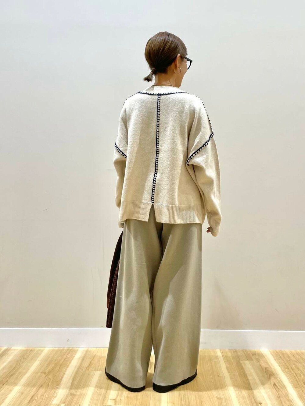 ホワイト系のニット/セーター、ブラック系のダウンジャケット/コート、ベージュ系のその他パンツを着用したレディースの冬コーディネートの7枚目の写真