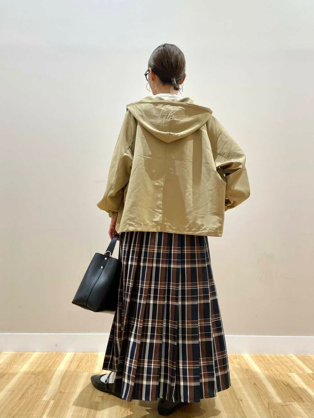 ブラック系のパンプス、ブラック系のトートバッグ、ブルー系のスカートを着用したレディースの秋コーディネートの3枚目の写真