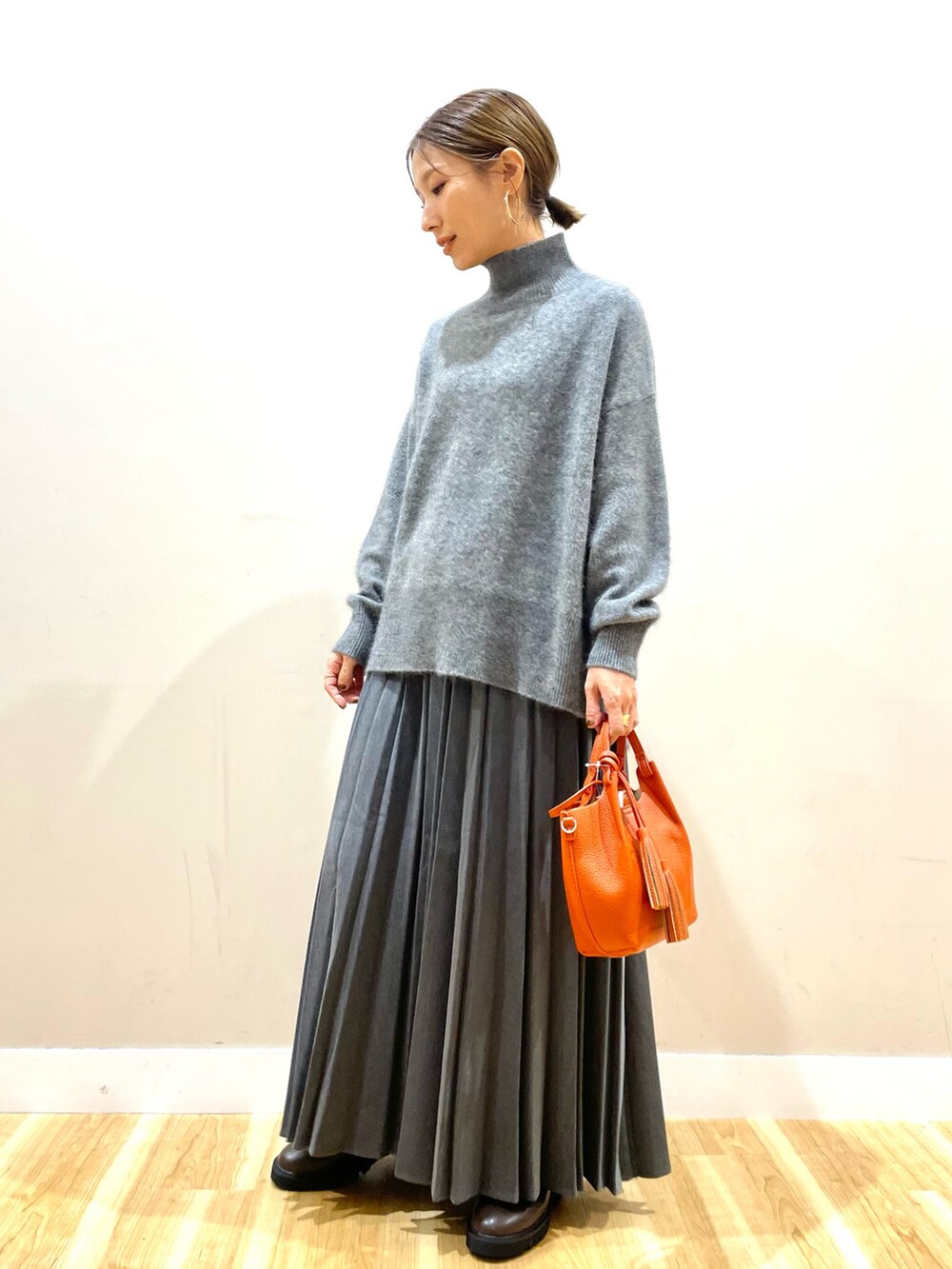 ホワイト系のダウンジャケット/コート、グレー系のニット/セーター、グレー系のスカートを着用したレディースの冬コーディネートの10枚目の写真