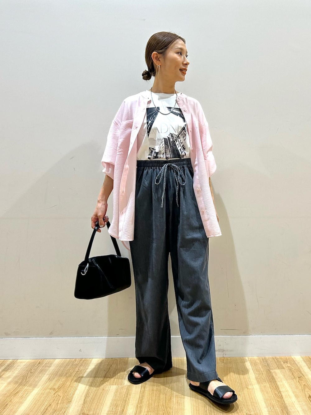 ピンク系のシャツ/ブラウス、ホワイト系のTシャツ/カットソー、ブラック系のデニムパンツを着用したレディースの春コーディネートの5枚目の写真