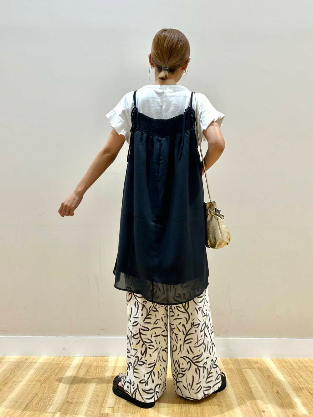 ゴールド系のショルダーバッグ、ホワイト系のその他パンツ、ホワイト系のTシャツ/カットソーを着用したレディースの夏コーディネートの4枚目の写真
