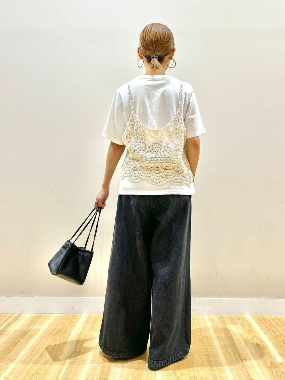 ブラック系のデニムパンツ、ベージュ系のTシャツ/カットソーを着用したレディースの夏コーディネートの3枚目の写真