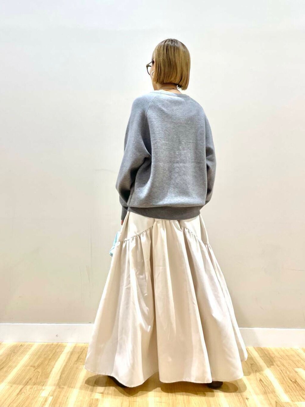 ブルー系のハンドバッグ、グレー系のワンピースを着用したレディースの秋コーディネートの2枚目の写真