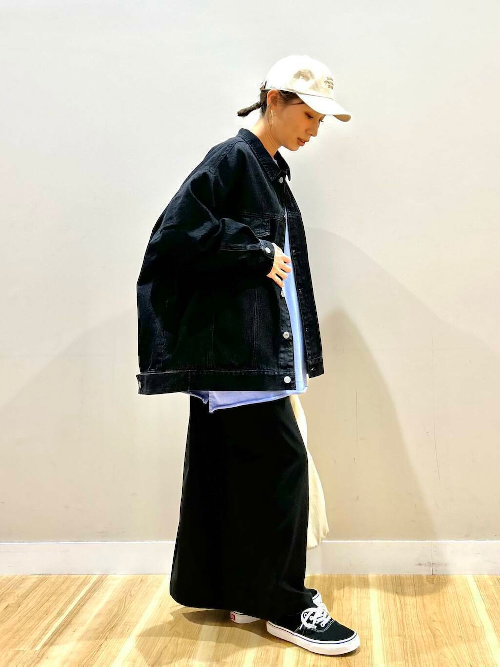 ブラック系のスニーカー、ホワイト系のトートバッグ、ブラック系のデニムジャケットを着用したレディースの春コーディネートの2枚目の写真