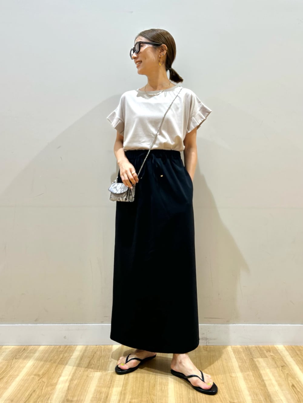 ベージュ系のTシャツ/カットソー、ブラック系のスカート、その他のショルダーバッグを着用したレディースの夏コーディネートの5枚目の写真