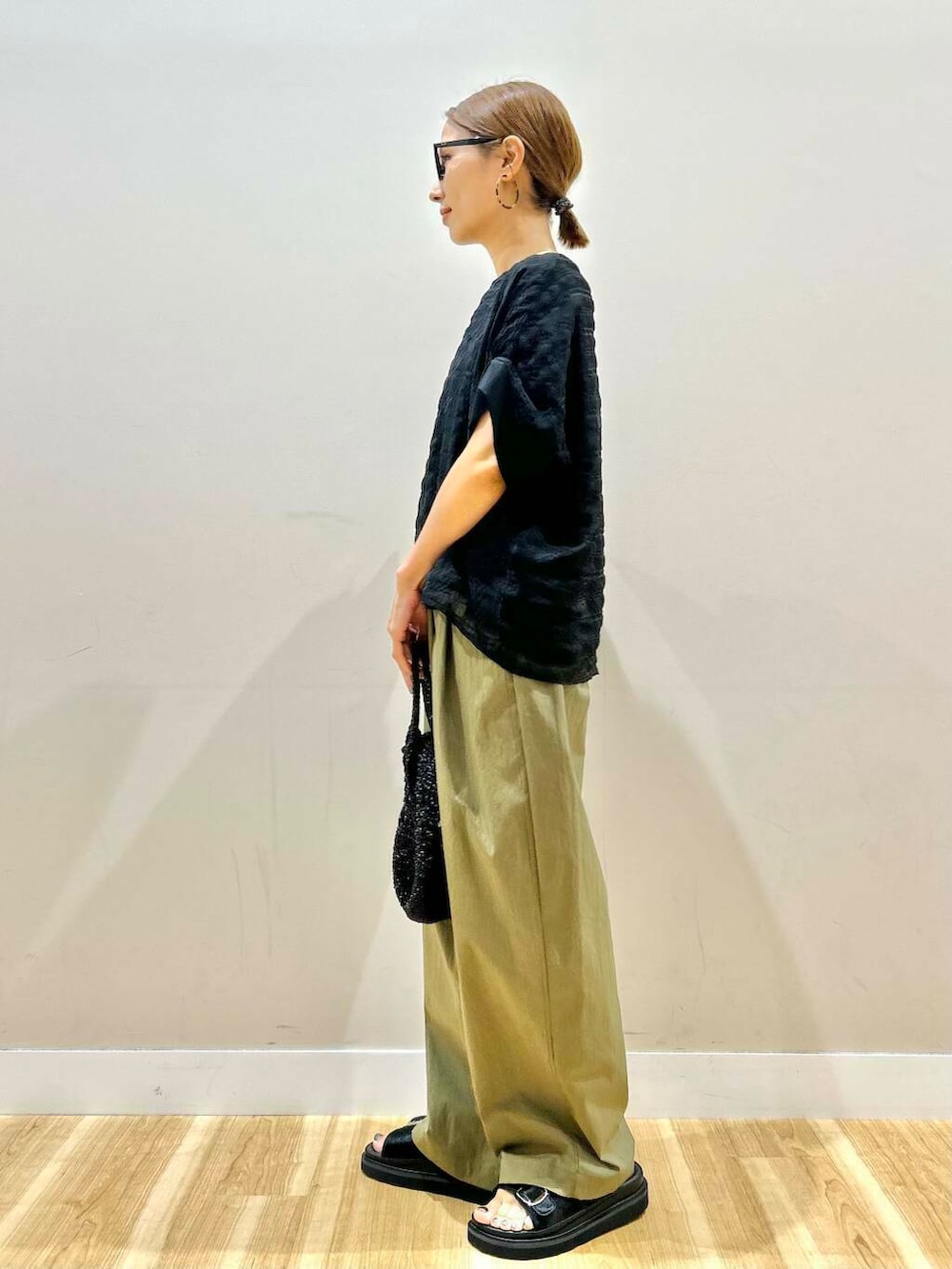 グリーン系のその他パンツ、ブラック系のショルダーバッグ、ブラック系のシャツ/ブラウスを着用したレディースの夏コーディネートの2枚目の写真