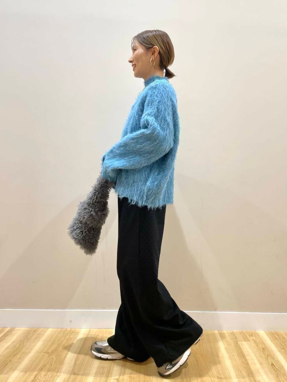 ブラック系のダウンジャケット/コート、ブルー系のニット/セーター、グレー系のハンドバッグを着用したレディースの冬コーディネートの8枚目の写真