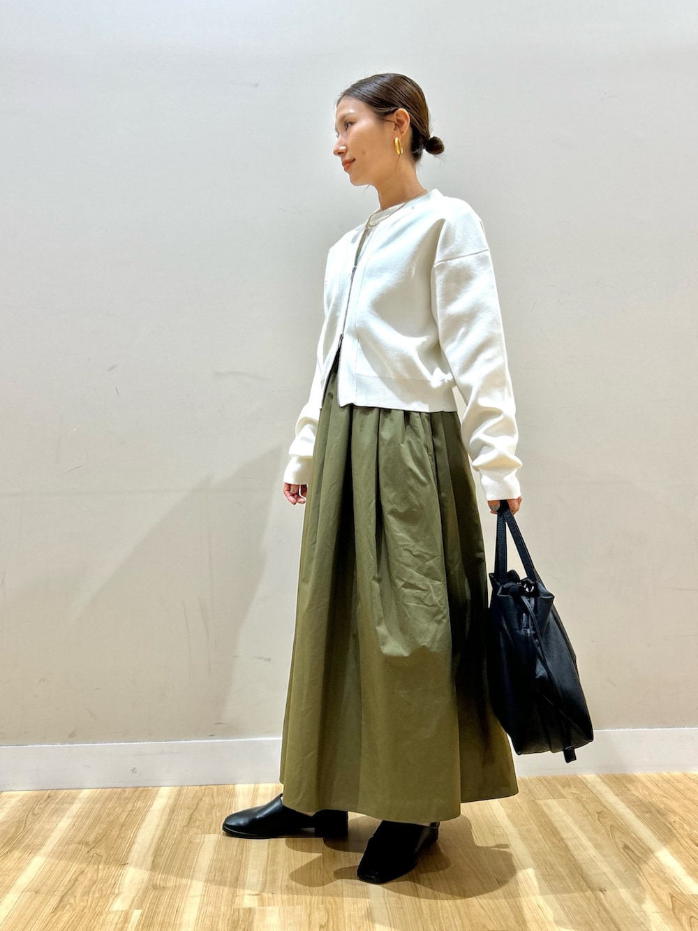 ホワイト系のカーディガン/ボレロ、ホワイト系のニット/セーター、グリーン系のスカートを着用したレディースの春コーディネートの2枚目の写真