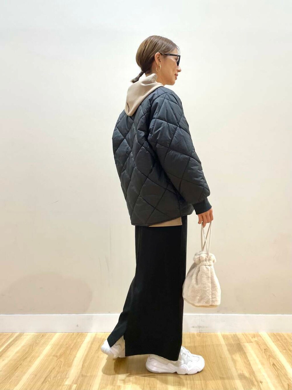 ホワイト系のスニーカー、ホワイト系のショルダーバッグ、ブラウン系のワンピースを着用したレディースの冬コーディネートの3枚目の写真