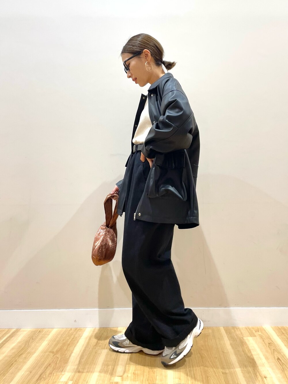 ブラック系のその他アウター、ホワイト系のニット/セーター、ブラック系のチノパンツを着用したレディースの秋コーディネートの4枚目の写真